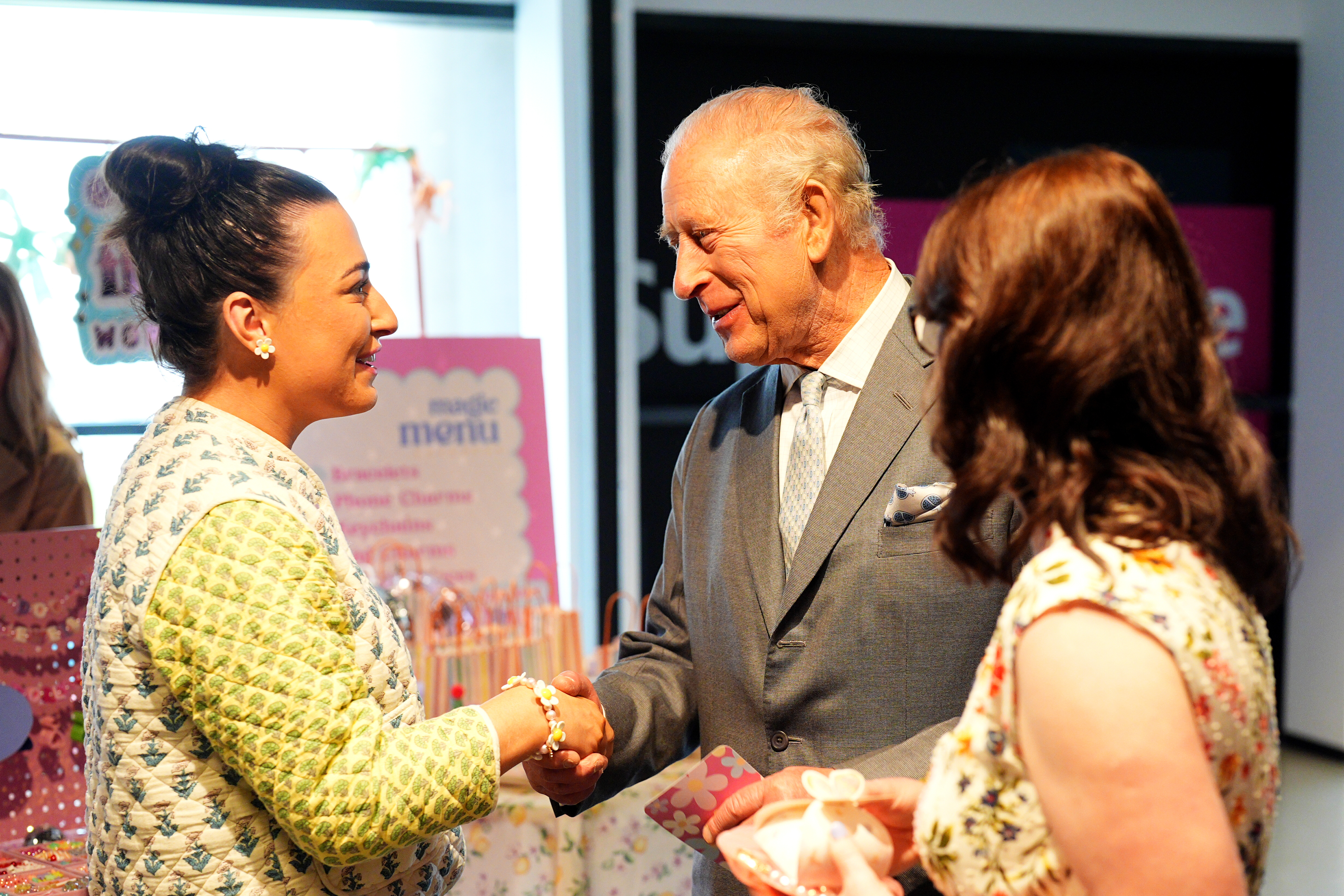 King Charles shaking hands with a woman