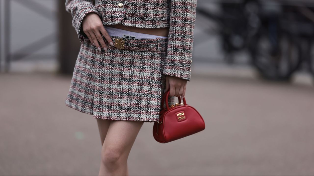 Woman wearing a Miu Miu mini-skirt suit and Miu Miu micro bag