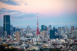 A city skyline at dusk with pink clouds