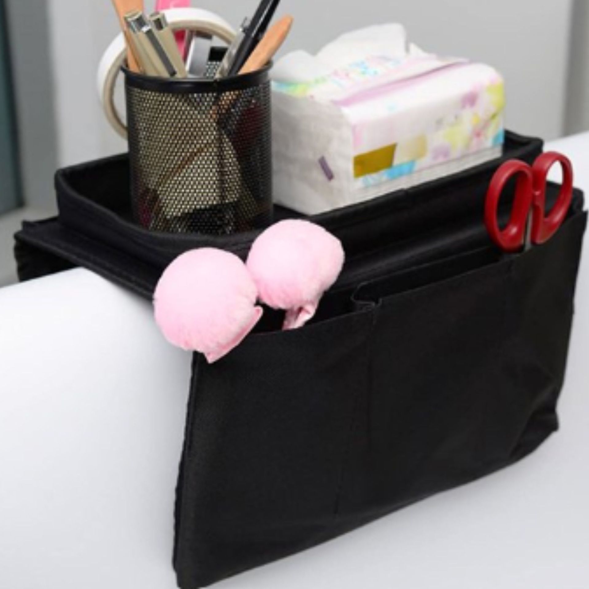 Dudukan sofa hitam dengan alat tulis di dalamnya