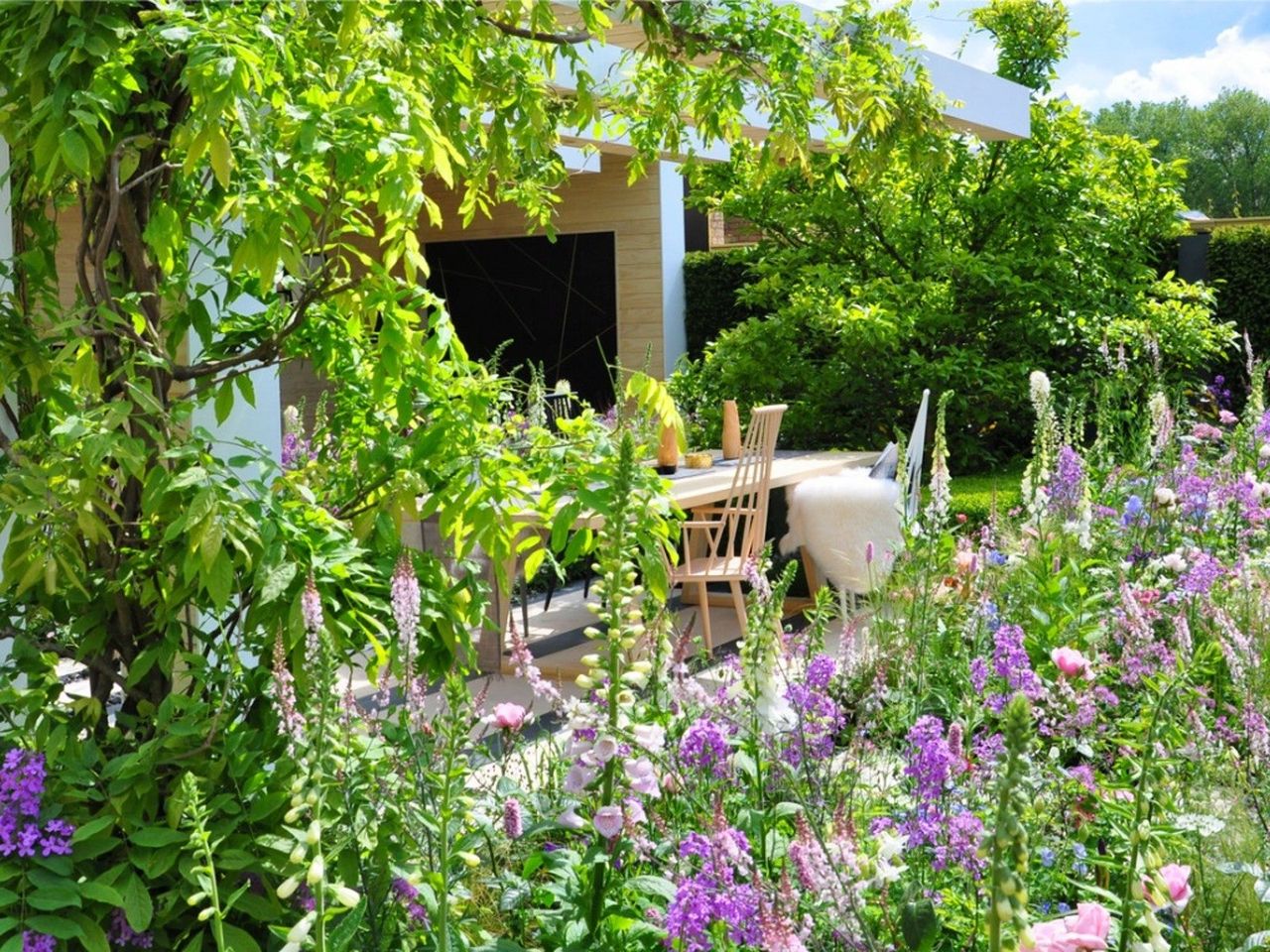 A table and chairs in a flower garden