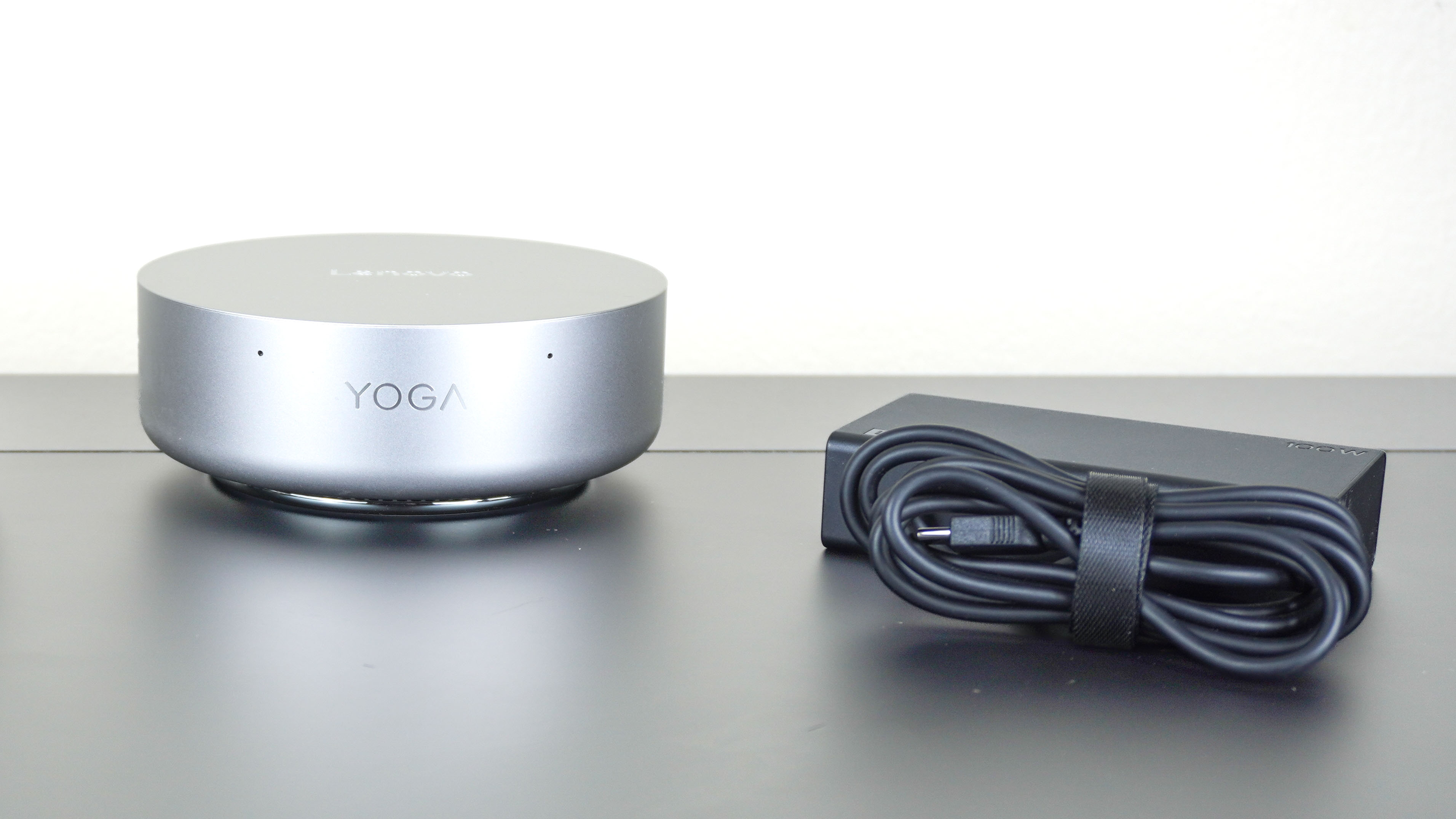 The Lenovo Yoga Mini next to its 100W power brick on a desk
