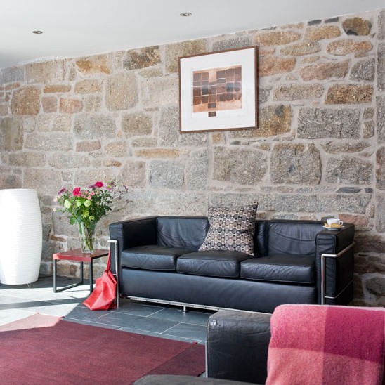 living room with black sofa and rug