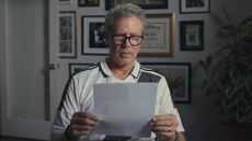 Will Ferrell wears glasses and reads a sheet of white A4 paper