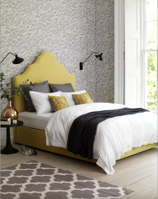 bedroom with yellow headboard and grey walls