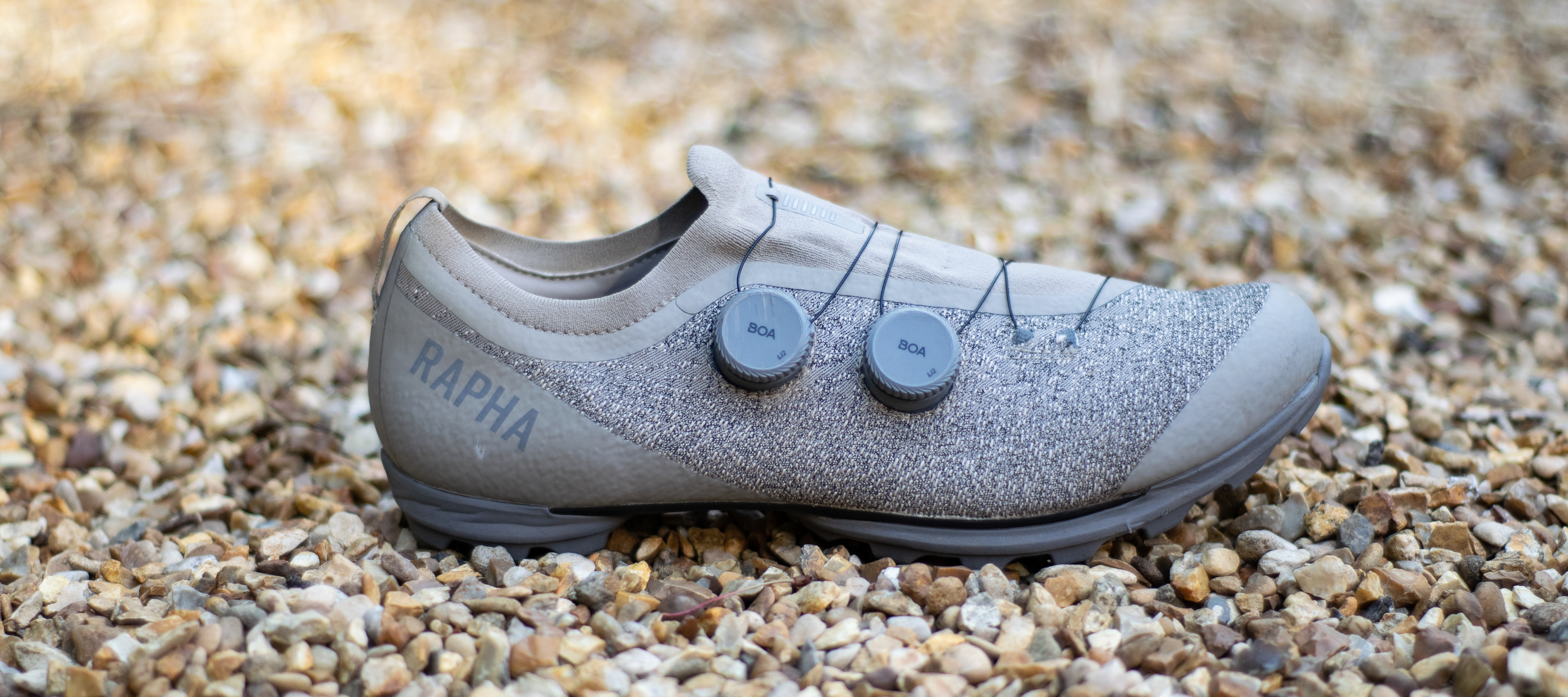 A pair of Rapha Pro Team Gravel shoes on some gravel 