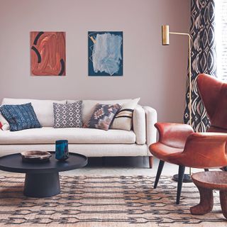 Living room with cream sofa, patterned rug and rust armchair.