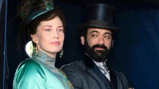 Bertha stares out of a carriage window while George looks at Bertha adoringly