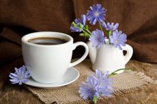 Cup Of Coffee On Table Covered In Chicory Flowers