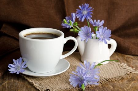 Cup Of Coffee On Table Covered In Chicory Flowers