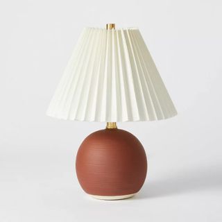A pleated lampshade on a table lamp