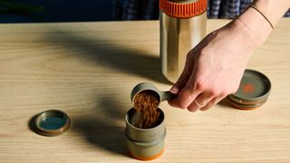 Wacaco Pipamoka portable coffee maker in front of a blue background.