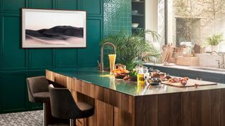 SAMSUNG The Frame QE75LS03AAUXXU 75" Smart 4K Ultra HD HDR QLED TV in a modern kitchen with a wooden island, green panelled wall, and a large window to the right