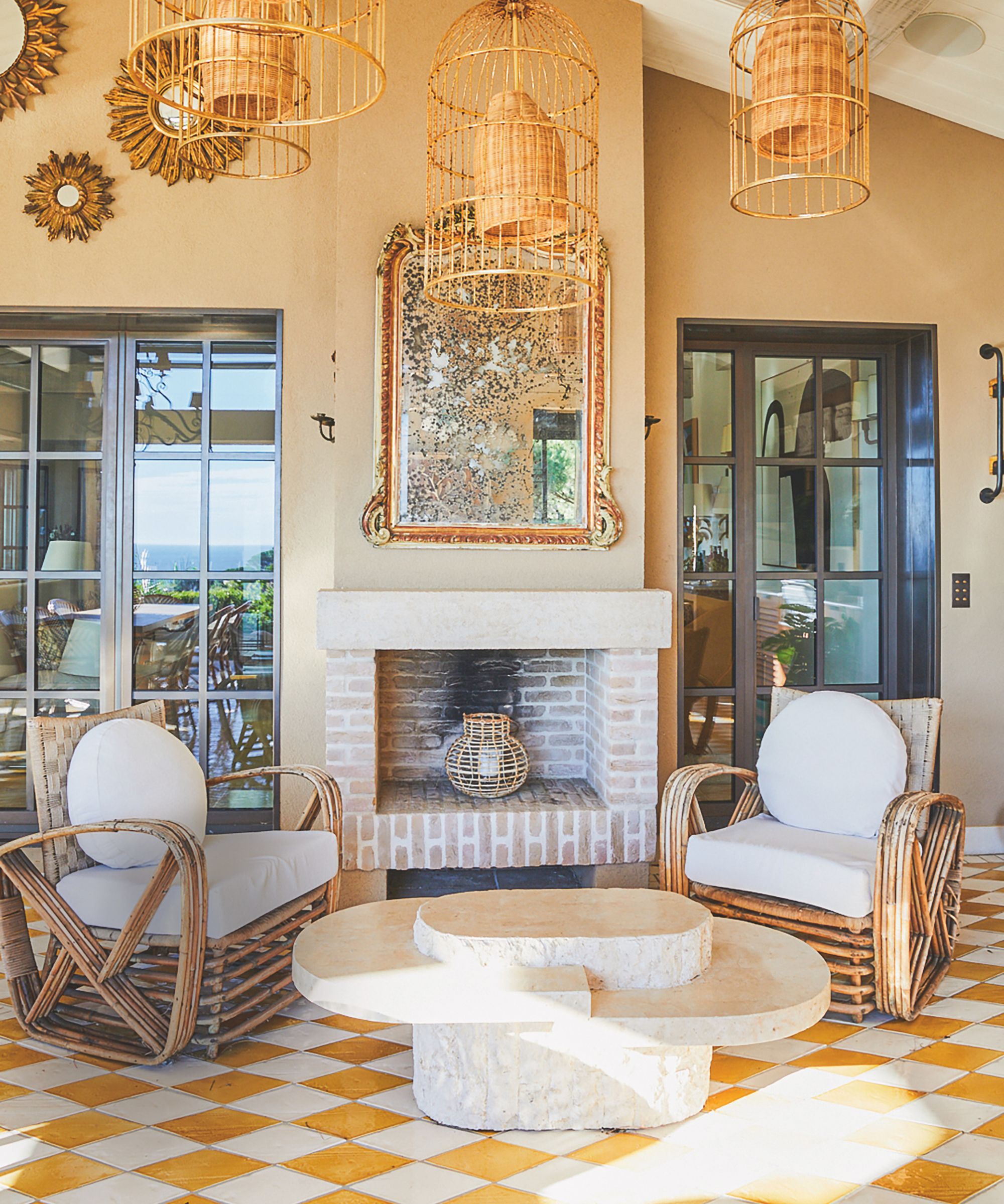 Patio sitting area with a brick fireplace, rattan chairs, a stone coffee table, and tiled floors