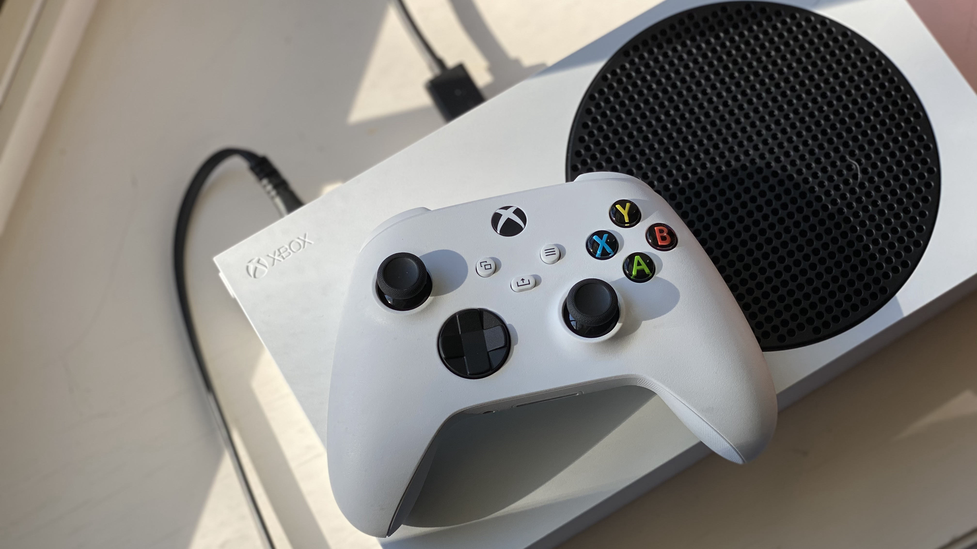 Xbox Wireless controller laying on top of the Xbox Series S