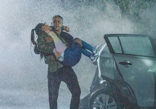 Dev Alahan carries his daughter from the burning wreckage.