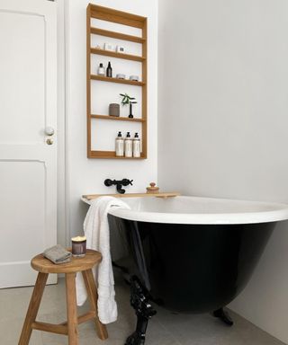 Small bathroom with black bathtub and open shelves