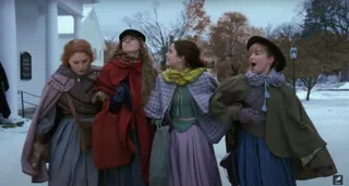 the march sisters in their winter coats walking through the snow in little women