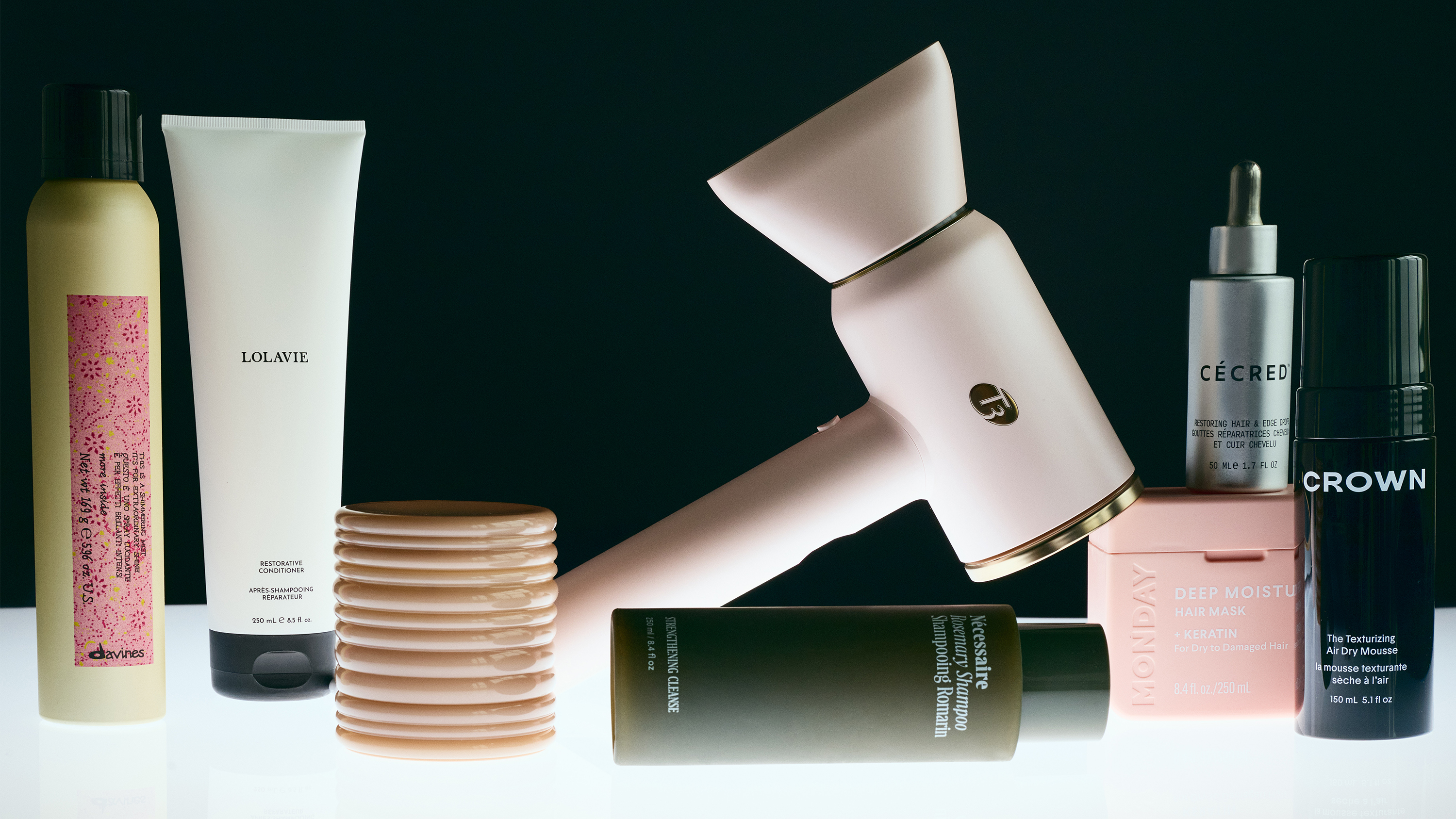 some of the products that won the marie claire skin and hair awards including lolavie product, a T3 blow dryer, and others on a black background