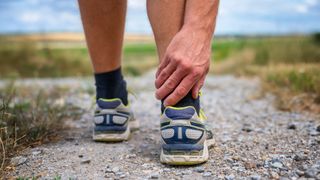 Man holding achilles tendon