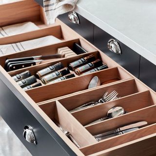 Open kitchen drawer with wooden organiser for cutlery and utensils