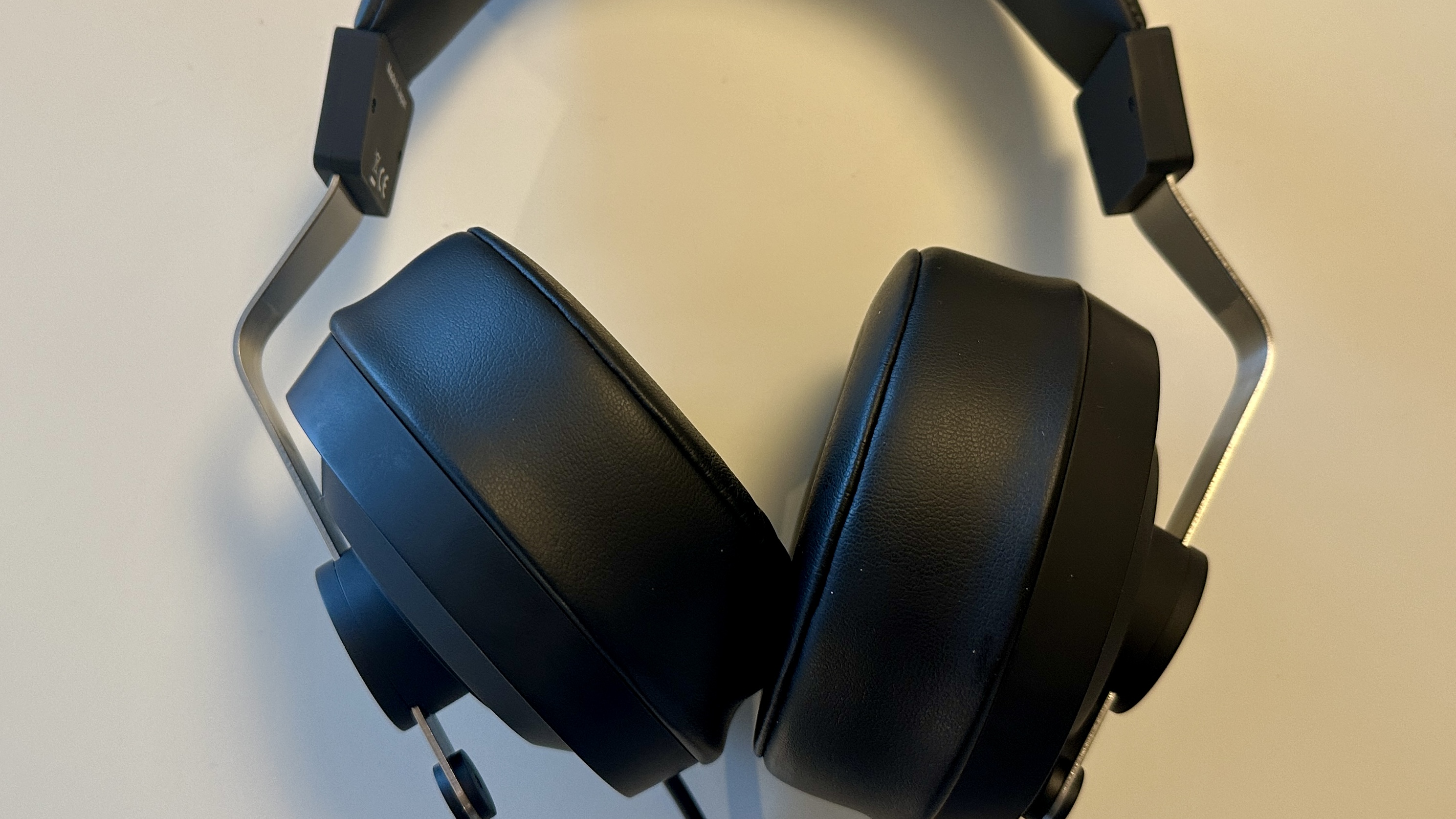 Close ups of the Final DX3000CL with a hi-res digital audio player, showing the ear cups, arm and screen on the player, all on beige background