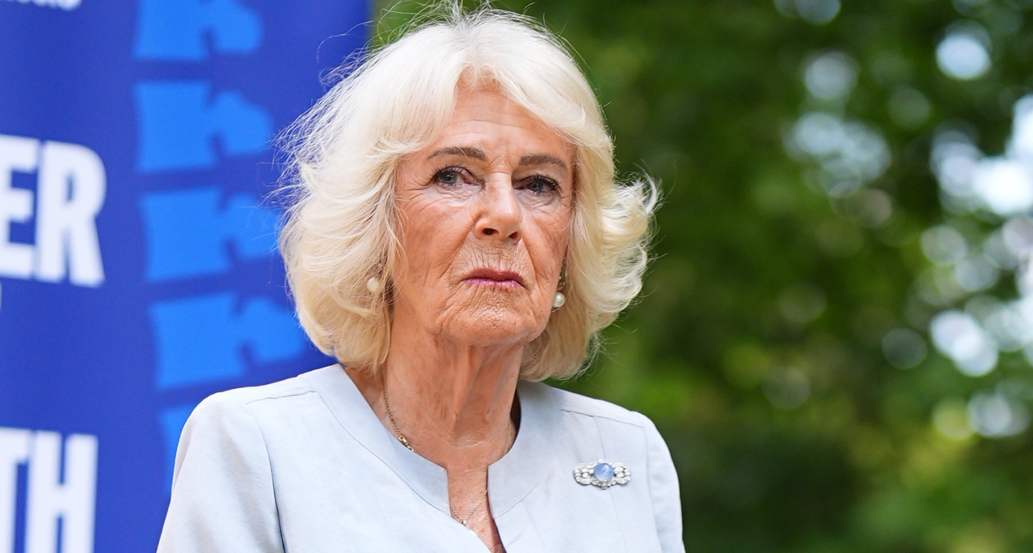 Queen Camilla giving a speech in front of a tree