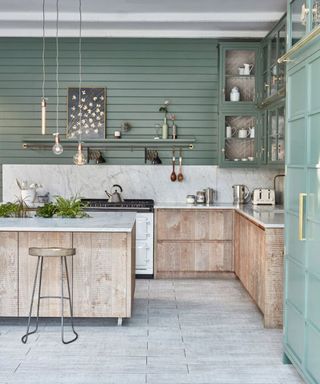 Pale green kitchen designed by Blakes London with rustic base units and white worktop