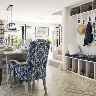 White living and dining area with modern design blue chair and accessory storage