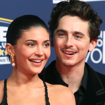 Kylie Jenner helps Timothee Chalamet get ready for their red carpet debut in Rome by using a lint roller on his velvet Tom Ford tuxedo