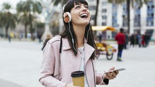Best music streaming services: Woman with coffee and listening to music