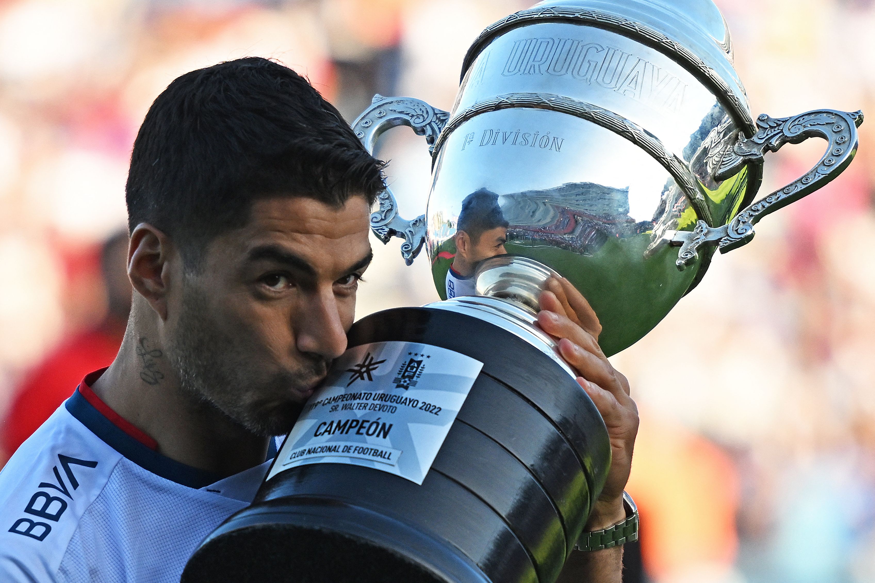 Luis Suarez kisses the Uruguayan championship trophy after winning the title with Nacional in November 2022.