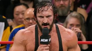 PAC addressing the wrestling world on AEW programming in 2025. He's wearing a black tank top with a serious look on his face. 