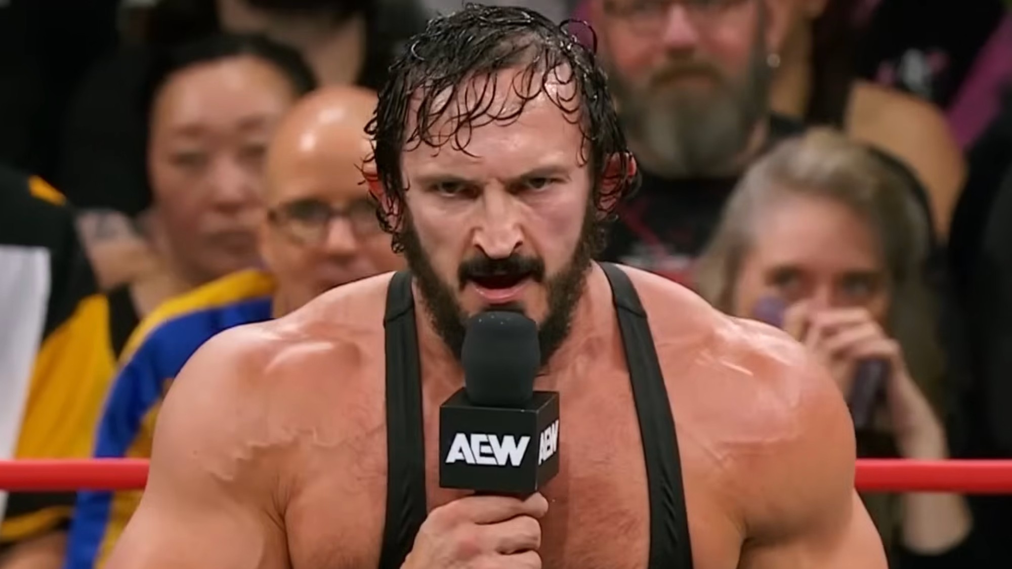 PAC addressing the wrestling world on AEW programming in 2025. He's wearing a black tank top with a serious look on his face. 