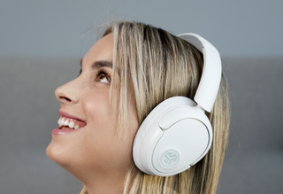 An image of a woman wearing the JBuds Lux ANC Wireless Headphones