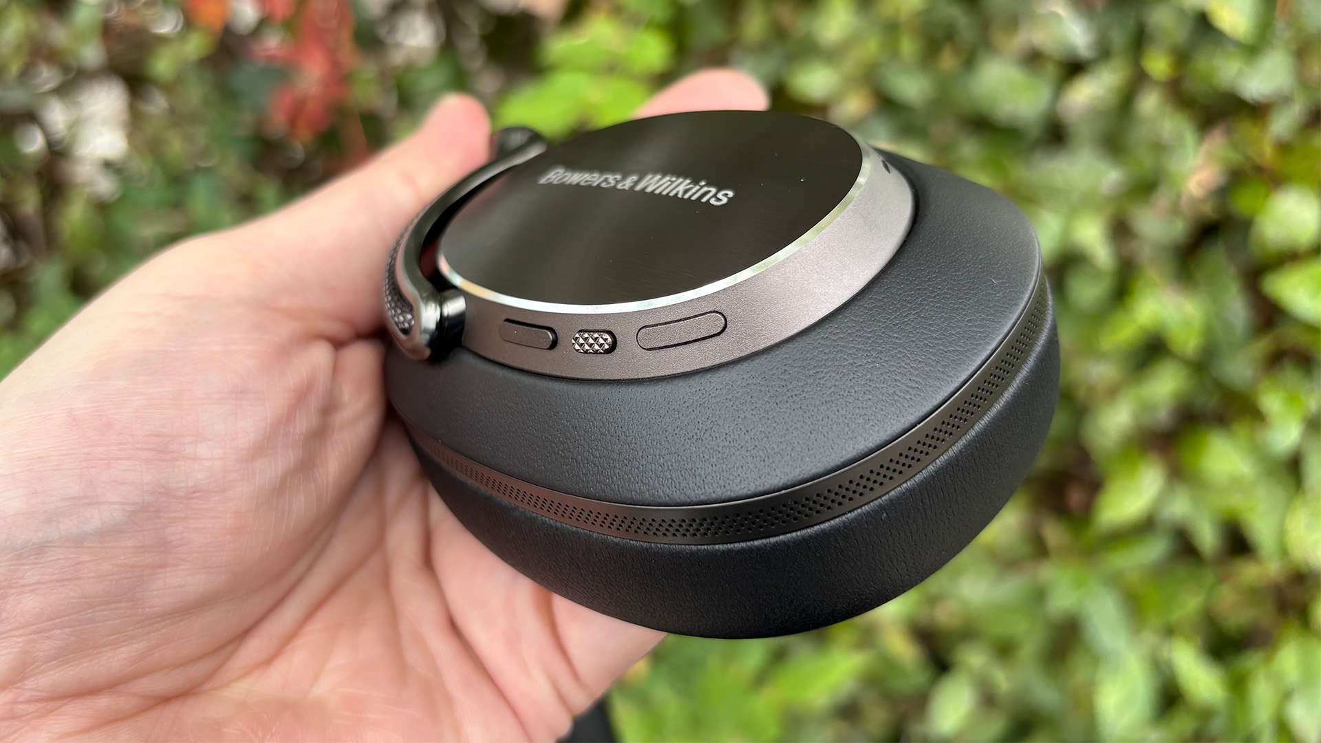 Bowers &amp;amp; Wilkins Px8 S2 wireless headphones one ear cup held in hand showing on-cup controls