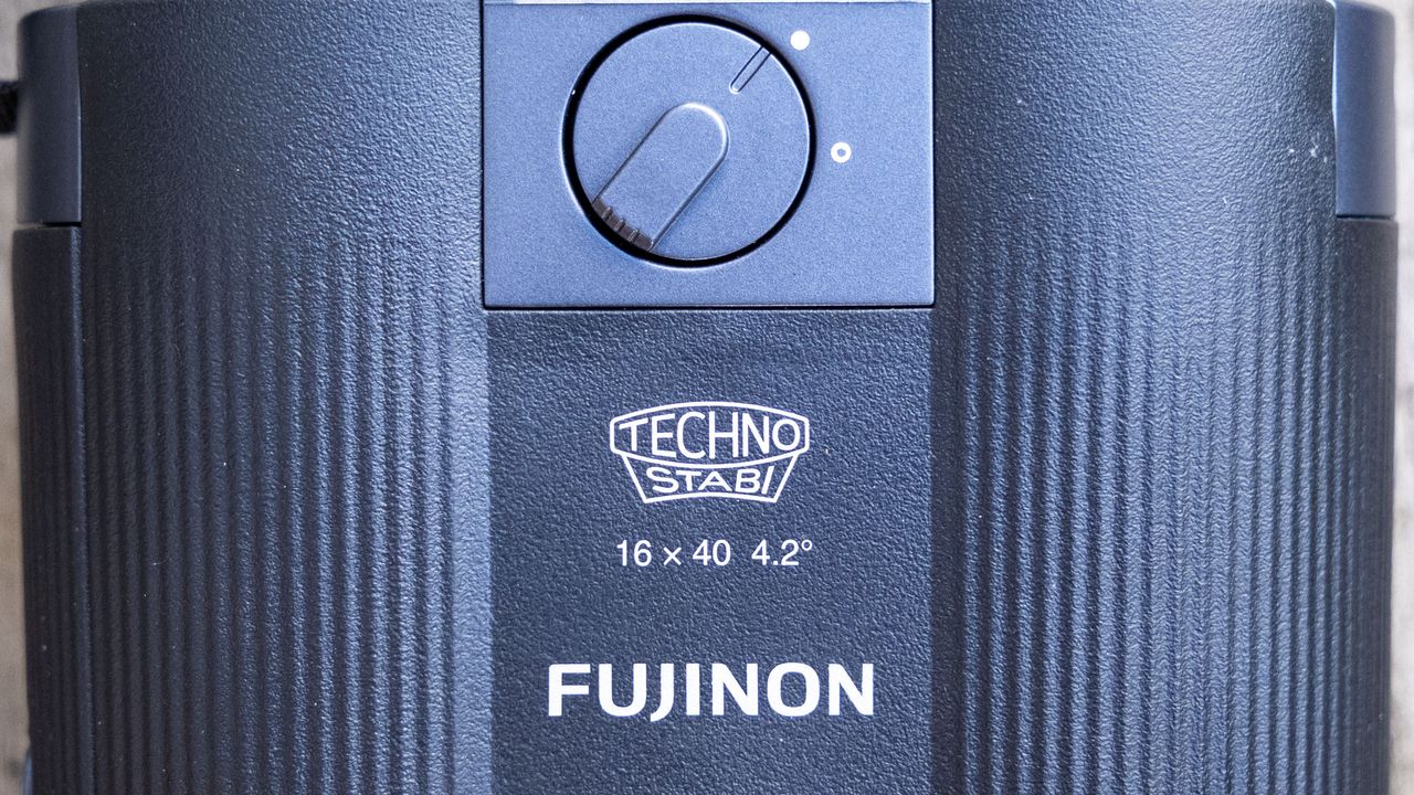 A close-up of the branding and image stabilization switch for the Fujifilm Techno-Stabi TS-L 1640 image-stabilized binoculars.