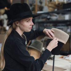 Hat-maker Gigi Burris attaching a veil to a felt cap
