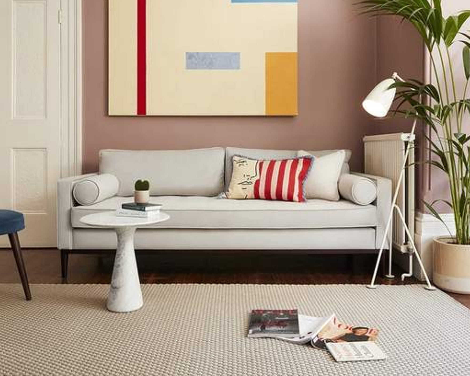 A pale grey sofa in a modern living room with contemporary art on the wall