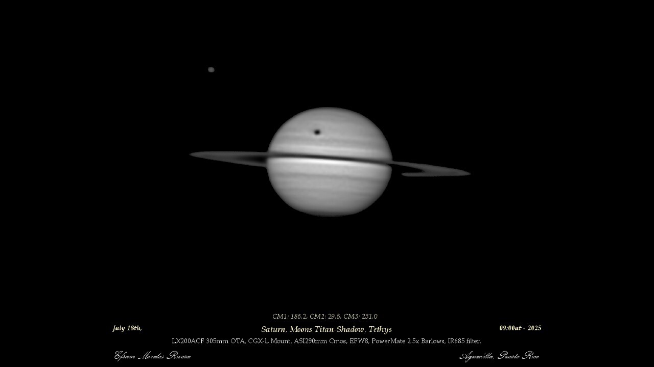 An image of the gas giant Saturn. The shadow of the large moon Titan is visible as a dark spot above its rings. Another Saturnian moon, Tethys, is visible to Saturn's upper left as a grey dot.