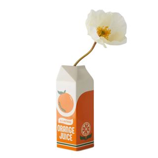 A vase shaped and painted orange to mimic a milk carton