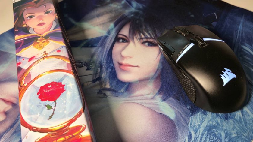 Photo of a black gaming mouse sitting on a Final Fantasy TCG playmat, with a Lorcana playmat to its left.