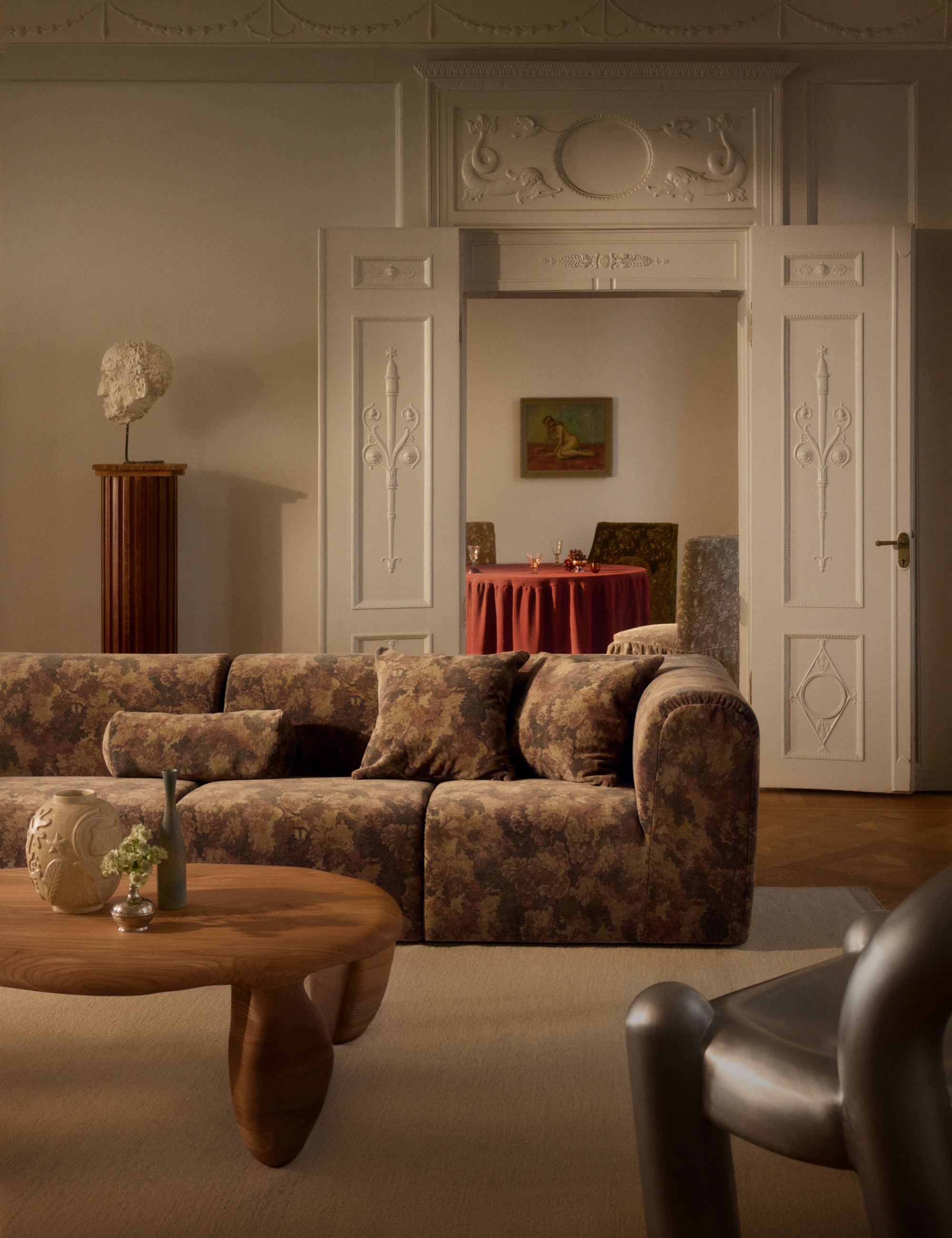 Ornate living room juxtaposing mid-century modern-style furniture with an antique tapestry-covered sofa