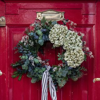 christmas wreath on a traditional red painted front door