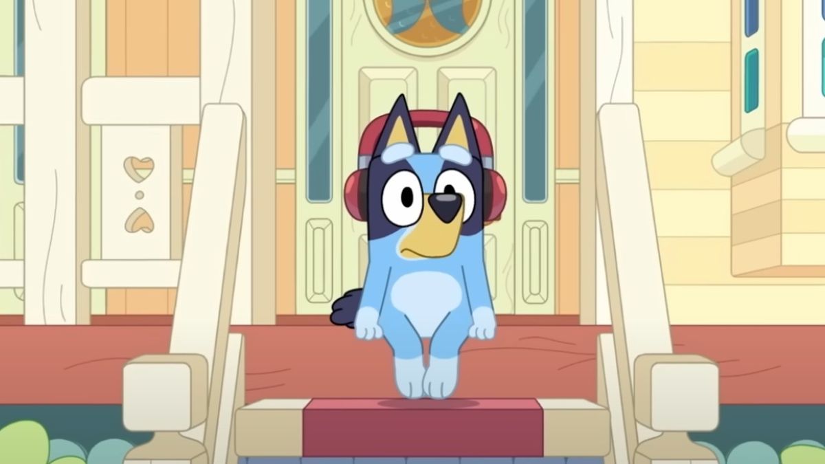 Bluey sitting on the steps wearing headphones