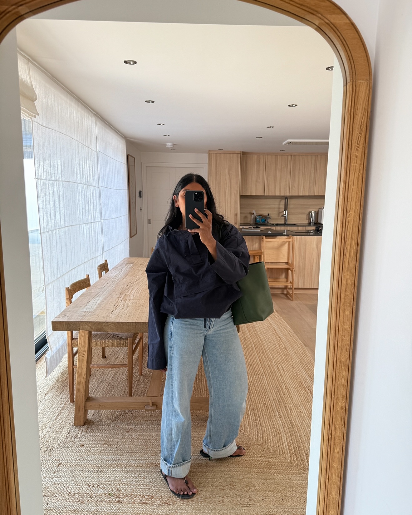 An image of @monikh wearing cuffed jeans with a windbreaker.