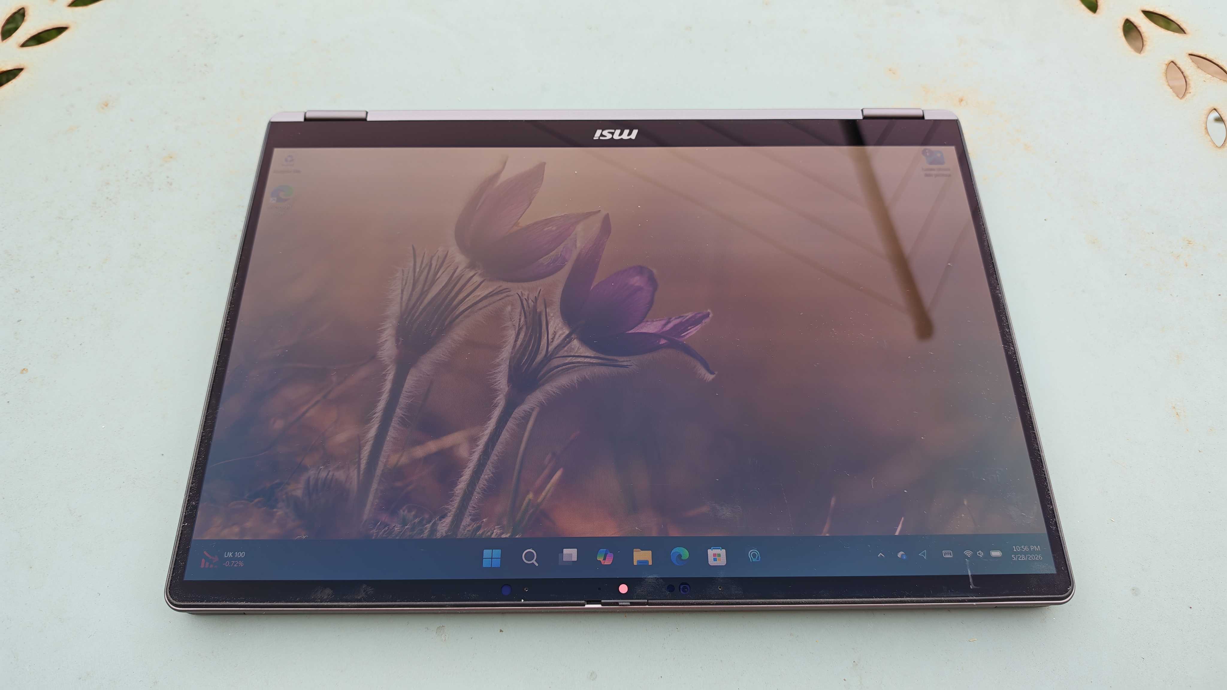 A silver MSI Prestige 14 Flip AI+ laptop on a garden table