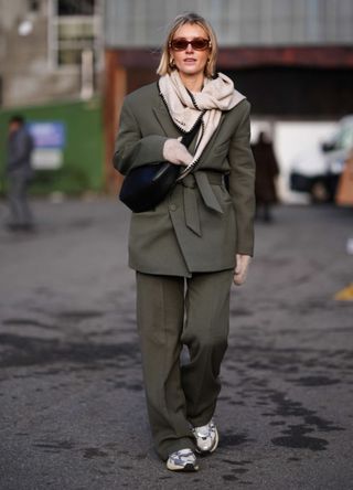 A woman wearing a blazer and scarf