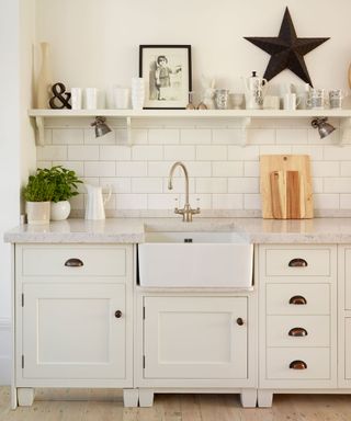 kitchen sink area with white cabinets