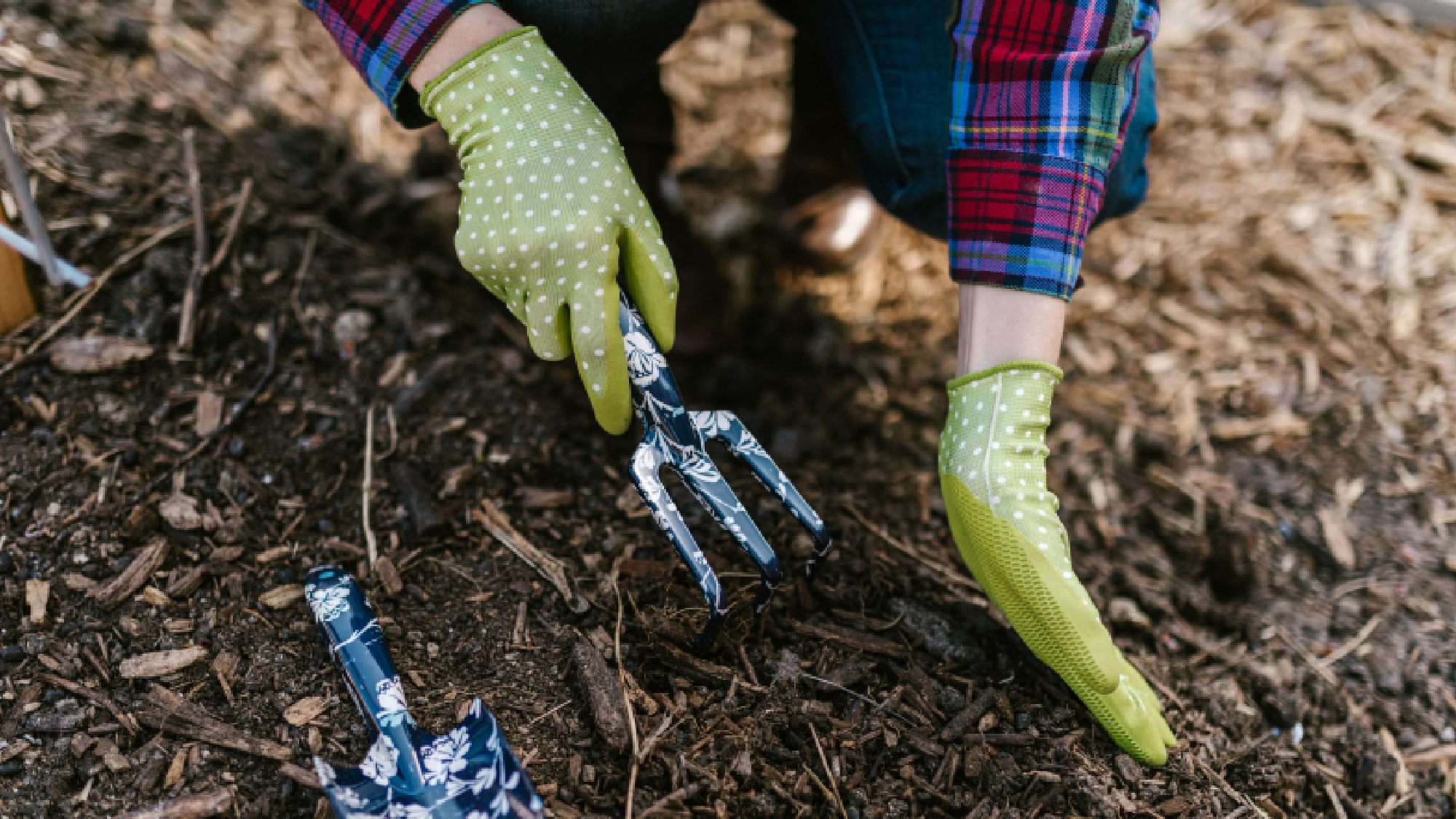 Person breaking down mulch with a rake